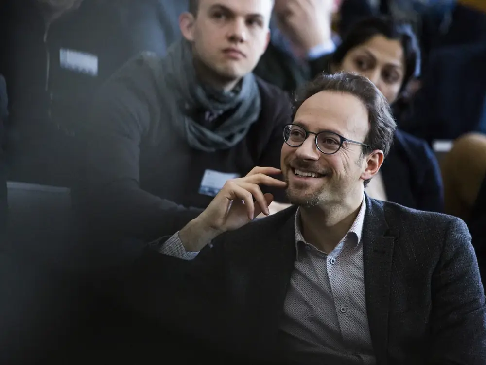 A listener in the audience, focused and attentive