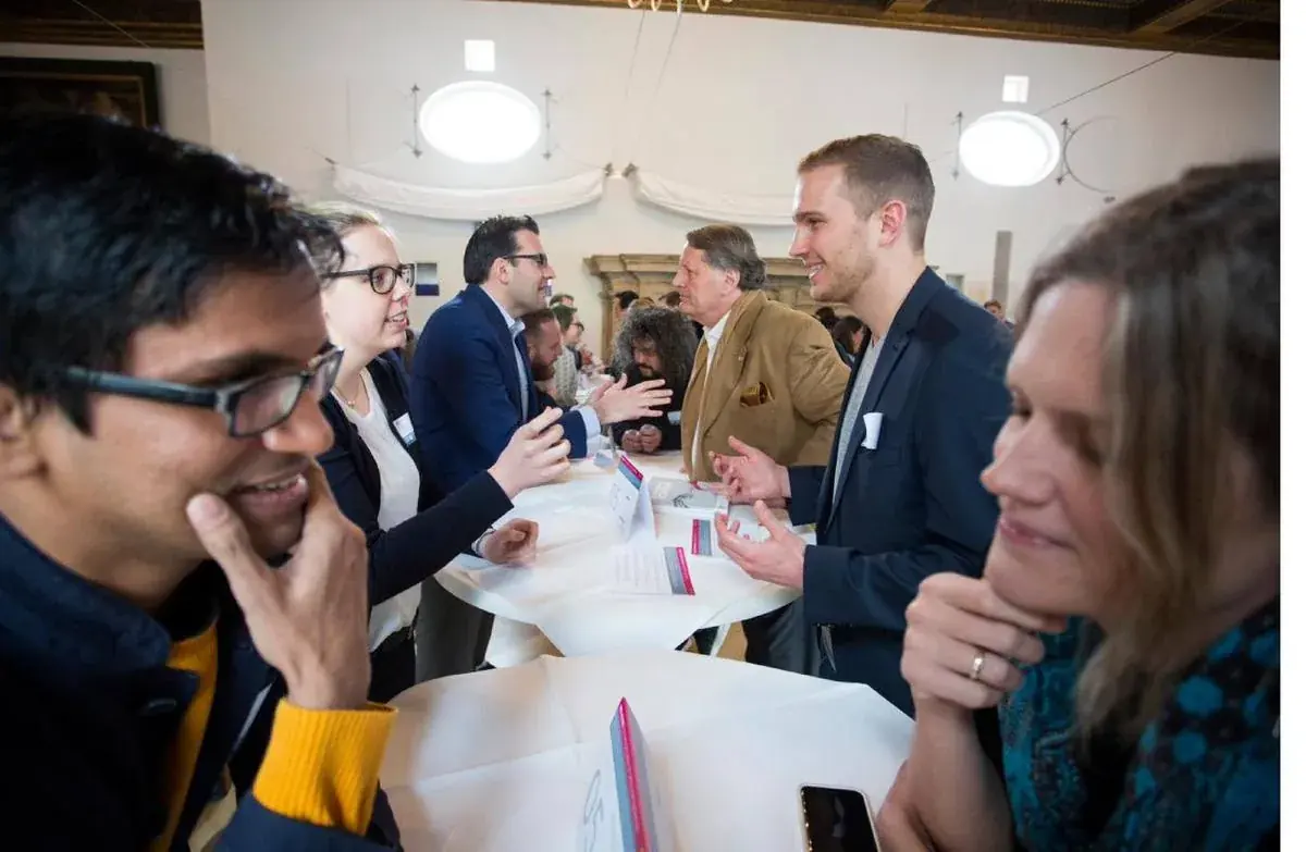 Leaders in conversation at standing tables during an MLI program