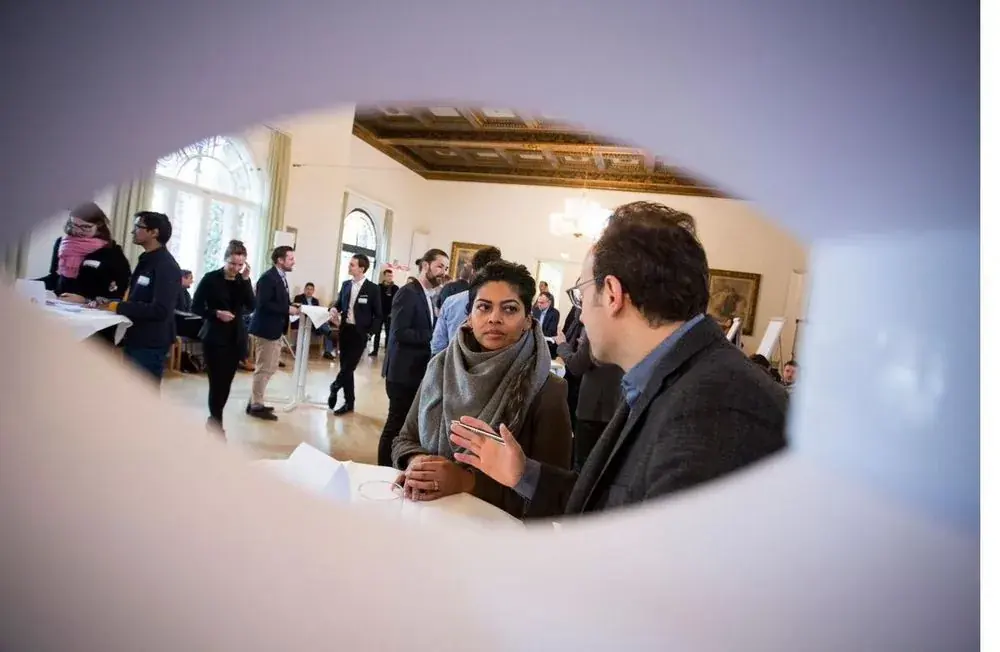 Two people in a confidential conversation on the sidelines of a leadership event